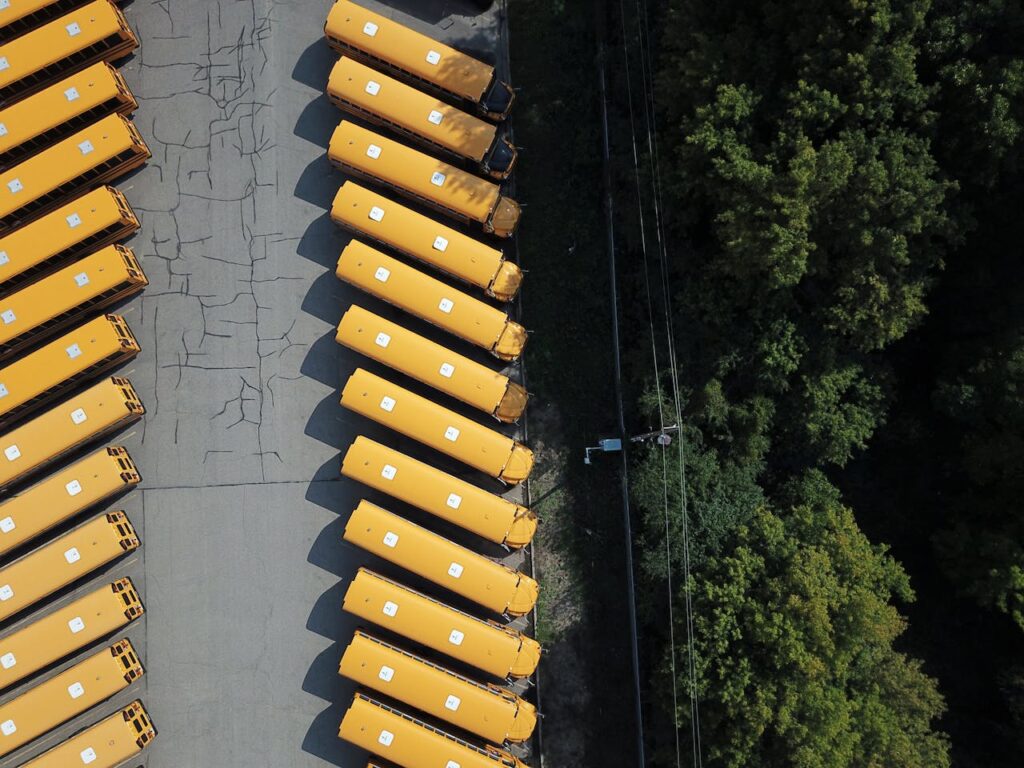 Aerial shot of yellow school buses lined up next to a forest area in Golden Valley, MN.